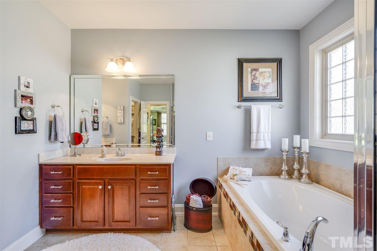 12819 Edsel Drive Raleigh, NC 27613 - Photo 16 of 30 a bathroom with a tub sink and mirror