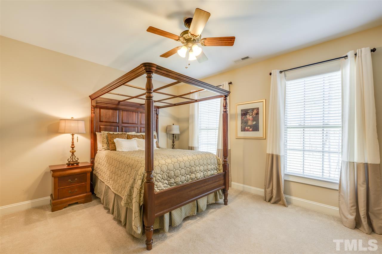 12819 Edsel Drive Raleigh, NC 27613 - Photo 19 of 30 a bed room with a bed and a chandelier