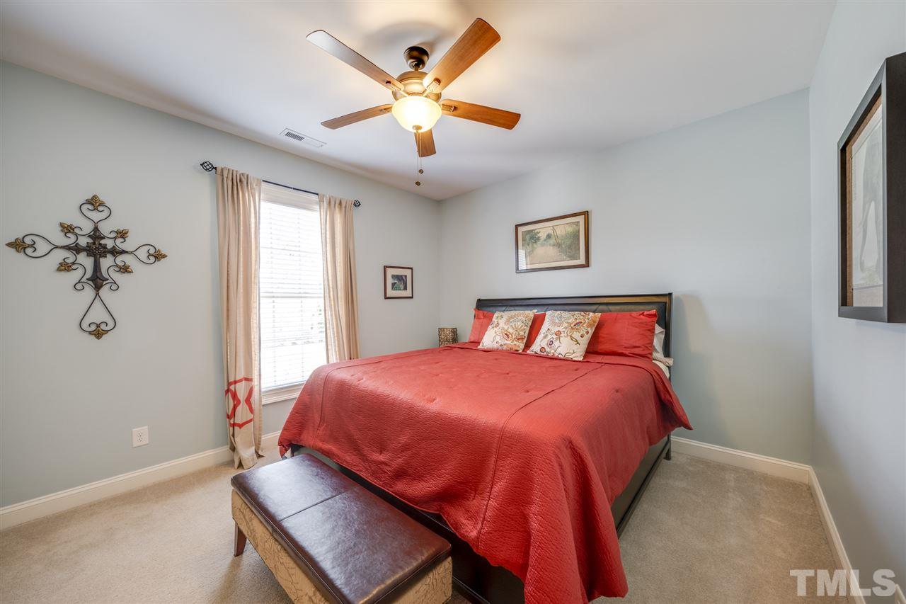 12819 Edsel Drive Raleigh, NC 27613 - Photo 20 of 30 a bedroom with a bed and a chandelier