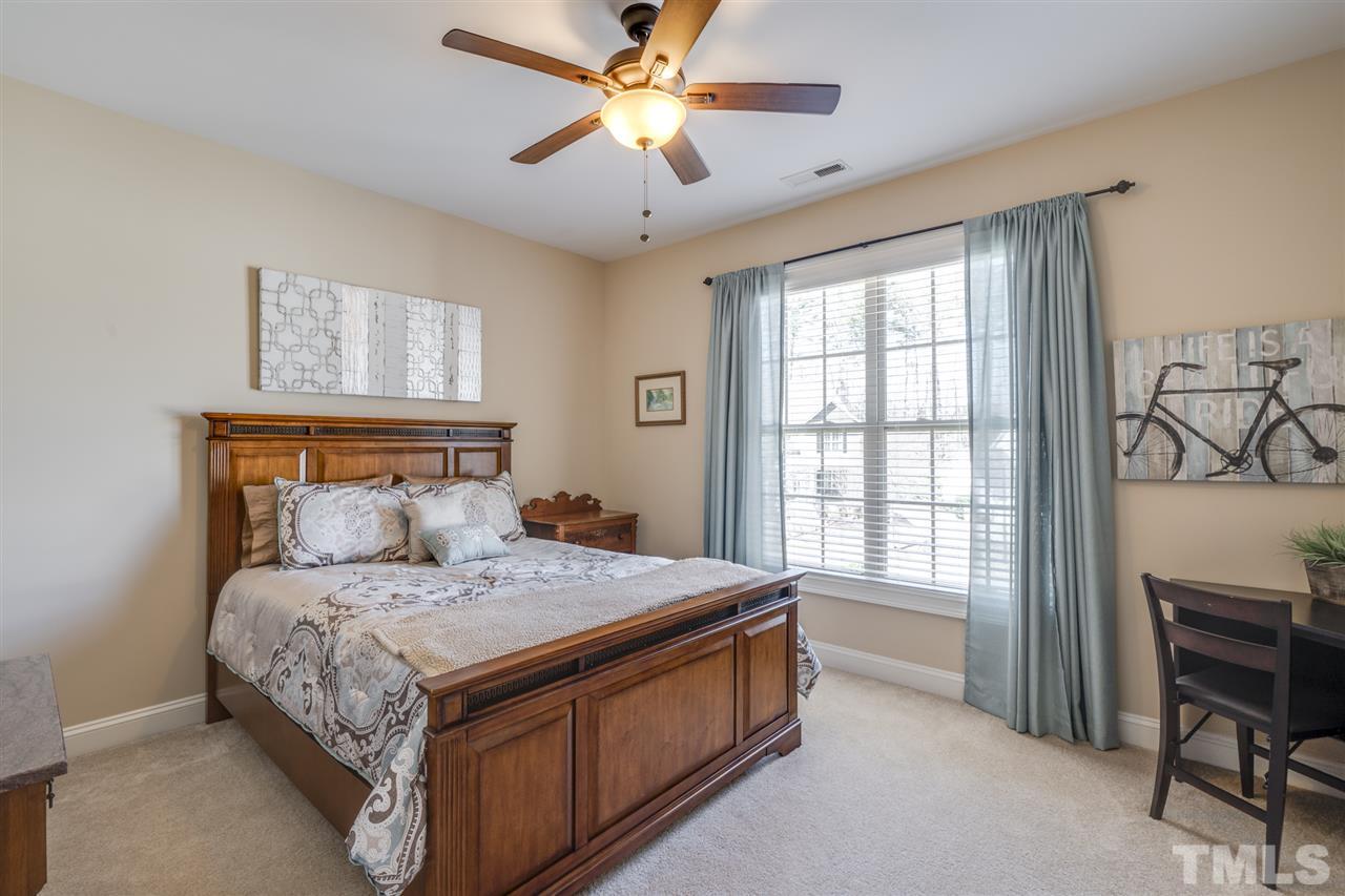12819 Edsel Drive Raleigh, NC 27613 - Photo 21 of 30 a bedroom with a bed and a chandelier
