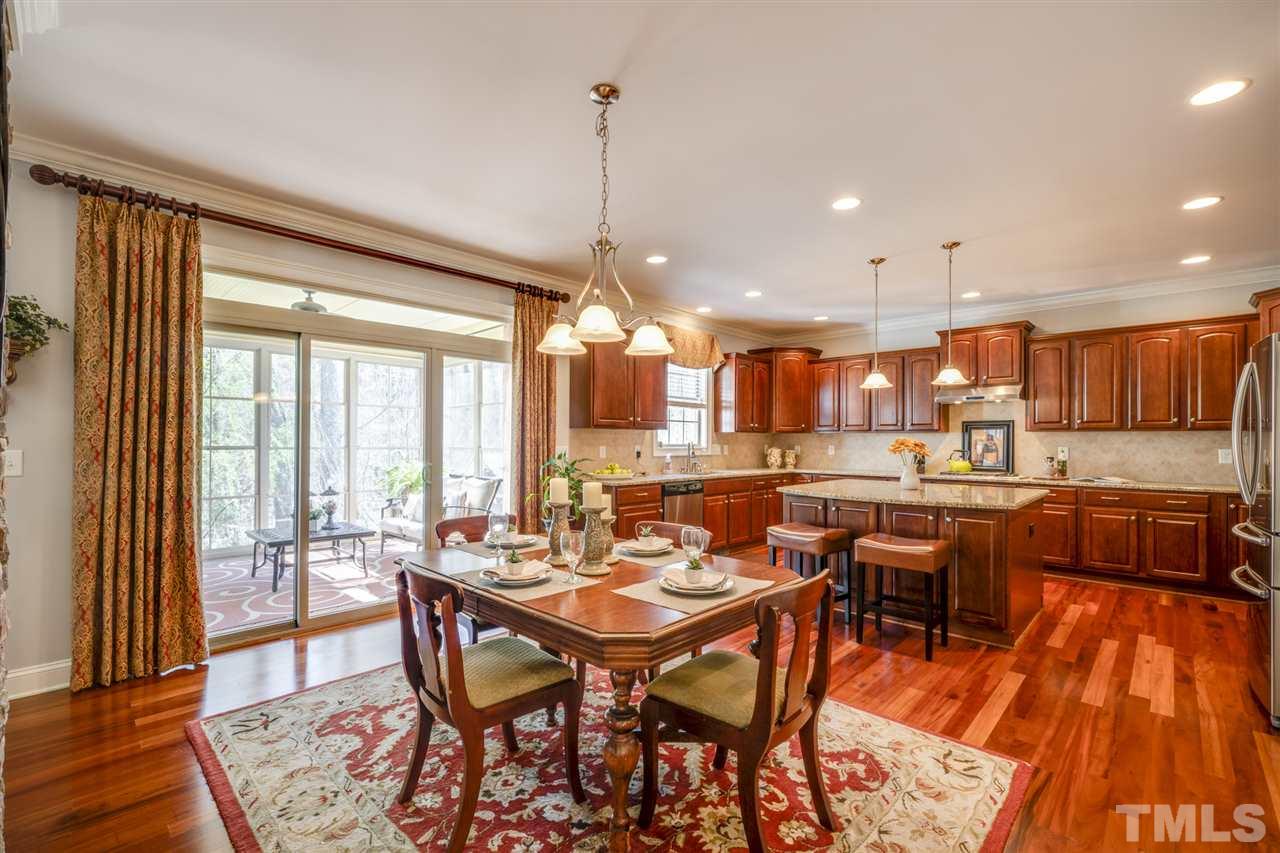 12819 Edsel Drive Raleigh, NC 27613 - Photo 10 of 30 a dining room with stainless steel appliances a table and chairs with wooden floor