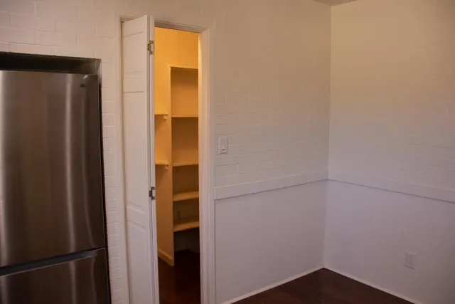 a bathroom with a walk in closet and wooden floor