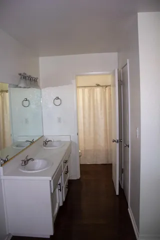 a spacious bathroom with a granite countertop sink a mirror and a bathtub