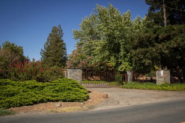 a front view of a house with a yard and trees