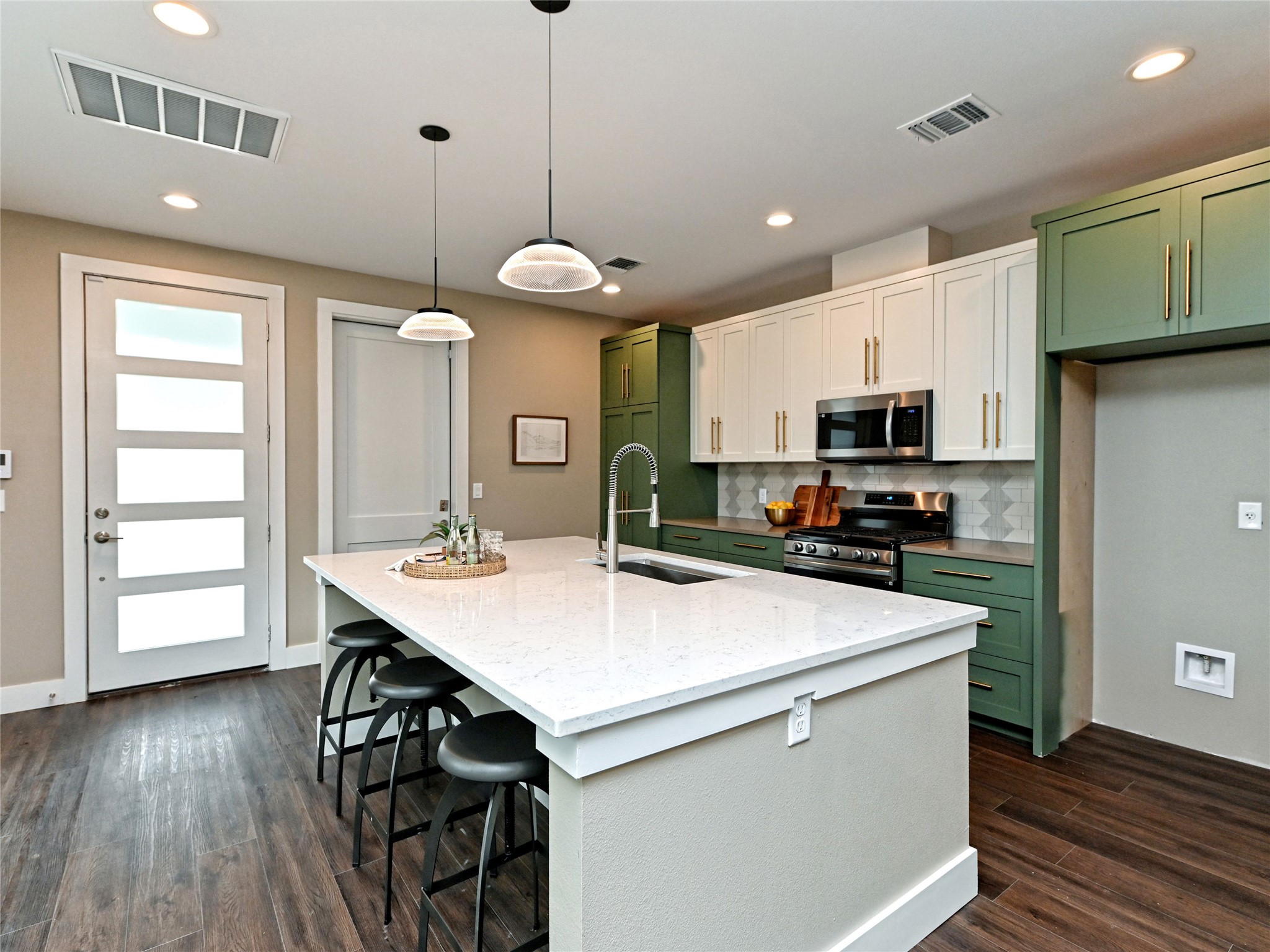 1202 Cometa Street, Unit B Austin, TX 78721 - Photo 9 of 25 a kitchen with kitchen island a wooden floor and white appliances