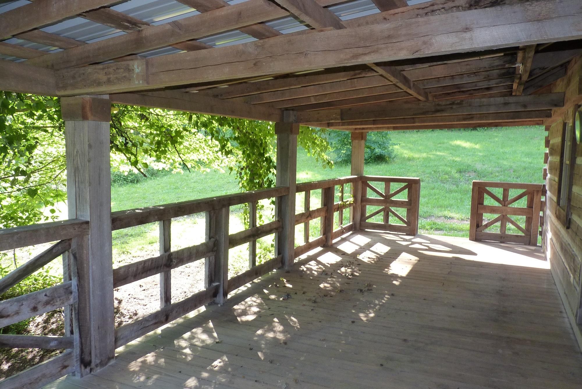 345 Cumberland View Road Clinton, TN 37716 - Photo 14 of 23 a view of porch with a table and chairs under an umbrella with a large window