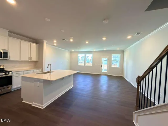 a large white kitchen with wooden floors and white walls