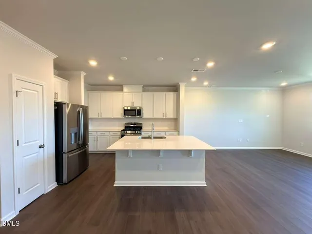 a view of kitchen with wooden floor and electronic appliances