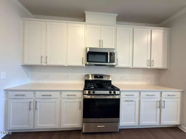 a kitchen with white cabinets and stainless steel appliances