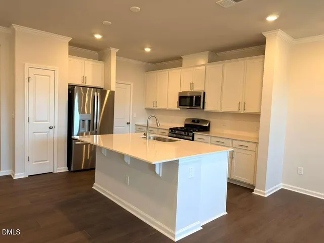 a kitchen with stainless steel appliances granite countertop a refrigerator stove microwave and sink