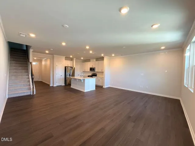 a view of kitchen with kitchen island wooden floor center island and stainless steel appliances