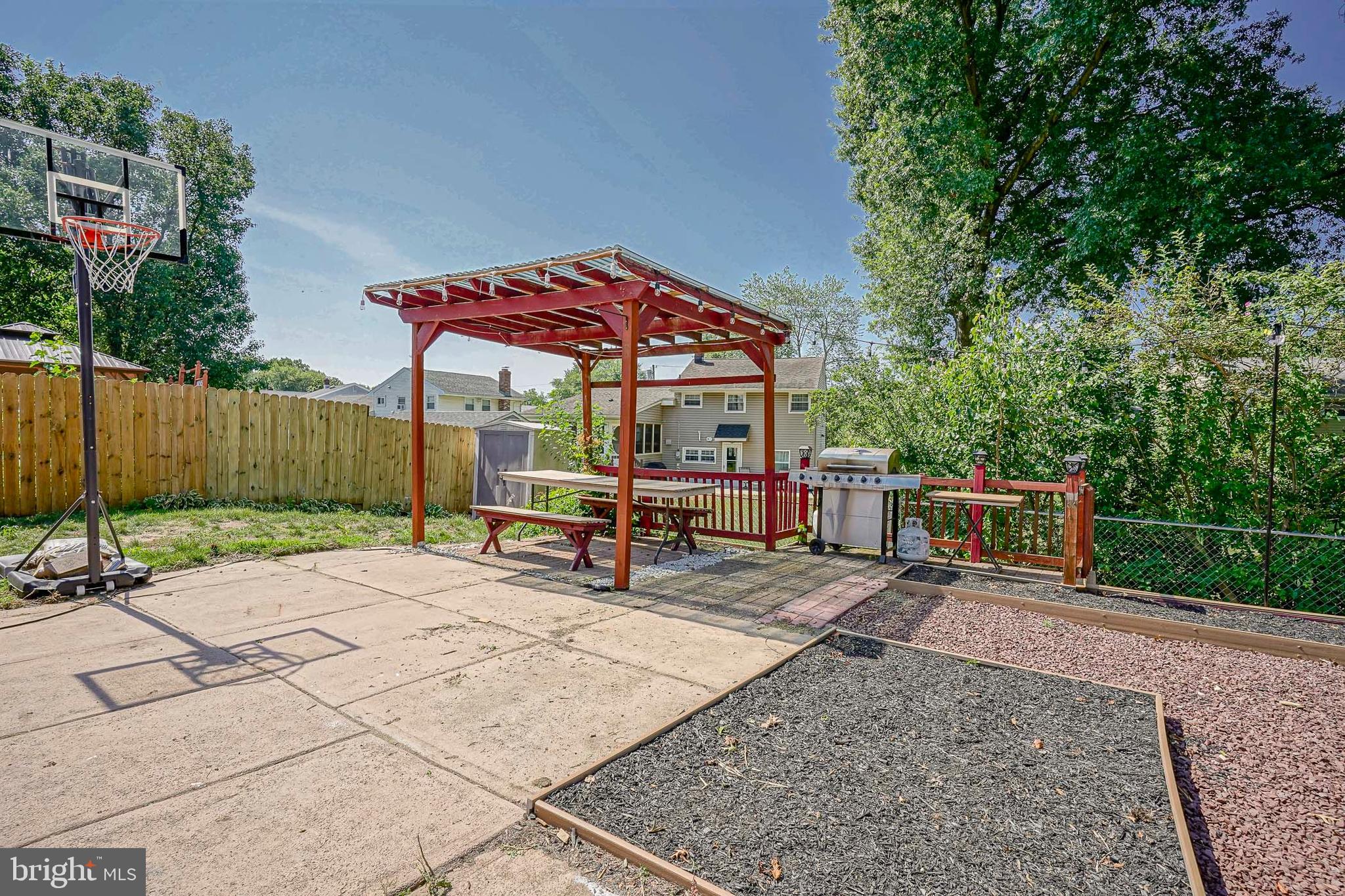 8 Rose Avenue Maple Shade, NJ 08052 - Photo 24 of 26 a view of a patio with a table and chairs under an umbrella with wooden fence