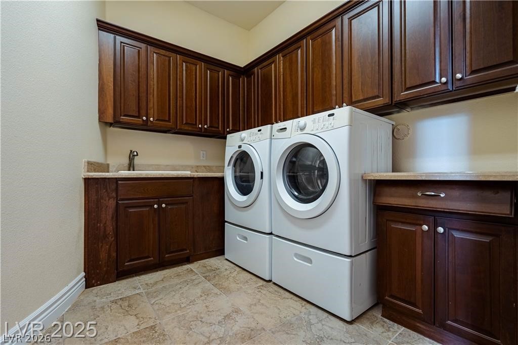 861 Majestic Ridge Court Henderson, NV 89052 - Photo 27 of 68 Laundry area with washer and clothes dryer, cabinet space, and light stone finish floors