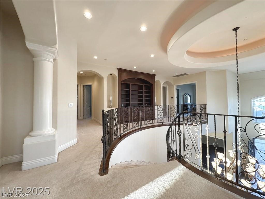 861 Majestic Ridge Court Henderson, NV 89052 - Photo 29 of 68 Corridor featuring carpet floors, a tray ceiling, arched walkways, recessed lighting, and decorative columns