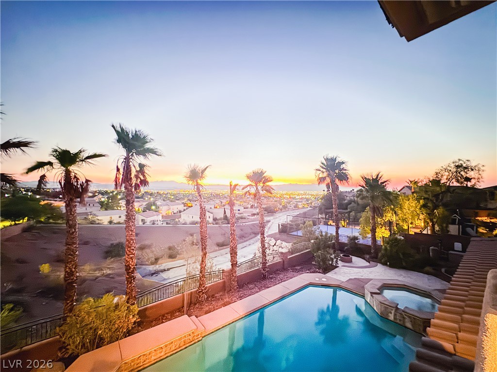 861 Majestic Ridge Court Henderson, NV 89052 - Photo 66 of 68 Pool at dusk with a fenced backyard and a pool with connected hot tub