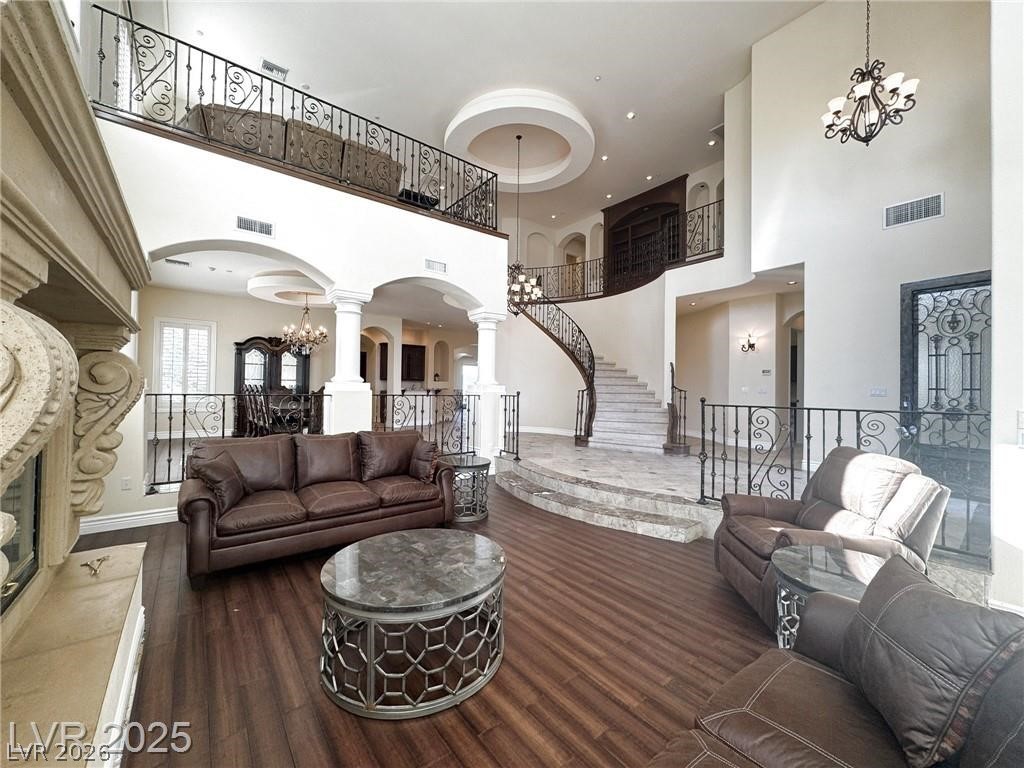 861 Majestic Ridge Court Henderson, NV 89052 - Photo 8 of 68 Living area featuring a chandelier, arched walkways, dark wood-type flooring, and a high ceiling