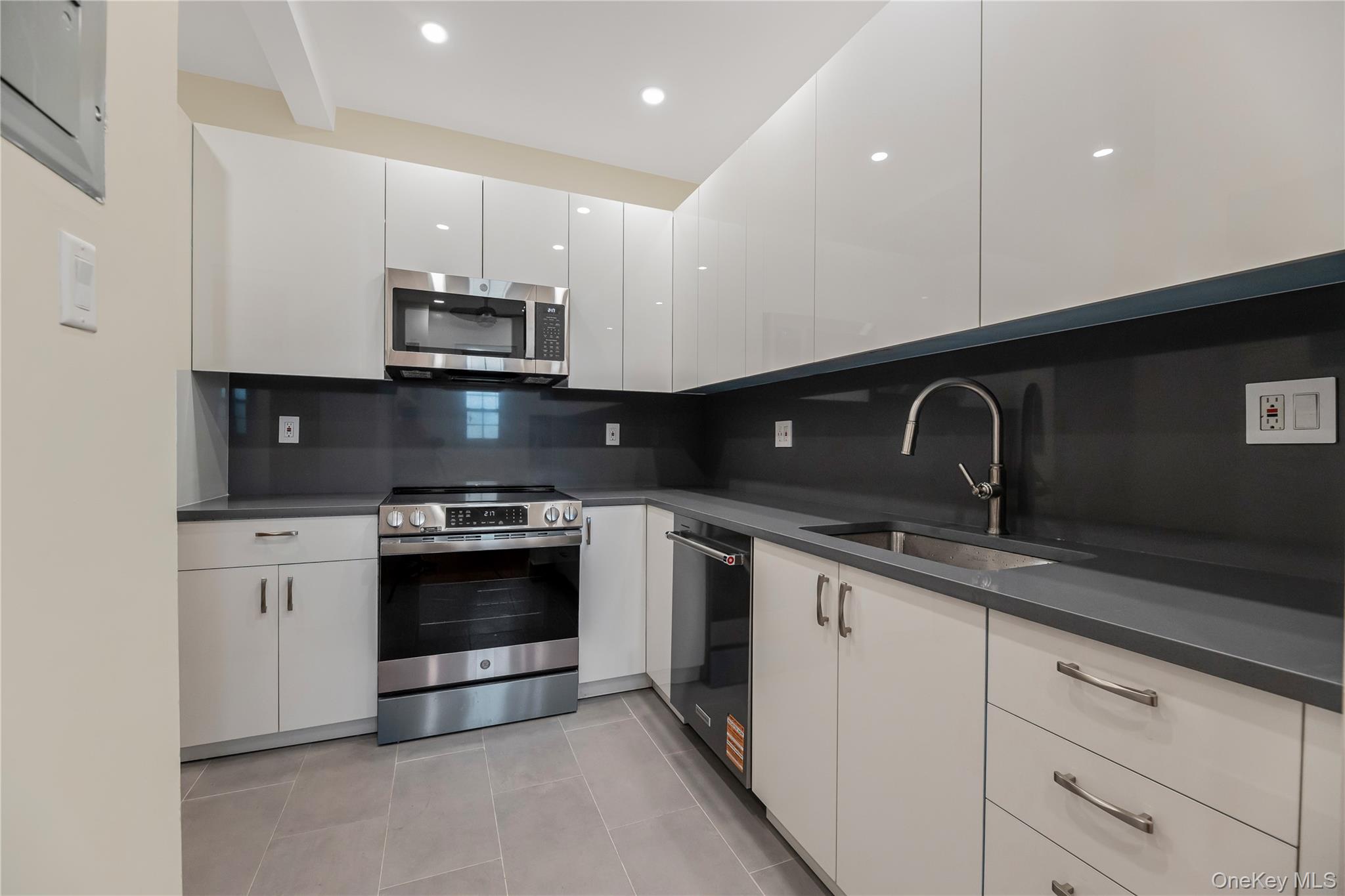 26 Pondfield Road, Unit 1D Bronxville, NY 10708 - Photo 7 of 21 a kitchen with stainless steel appliances granite countertop a sink and a stove