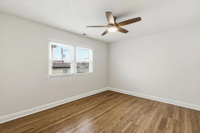 a view of a big room with wooden floor and windows