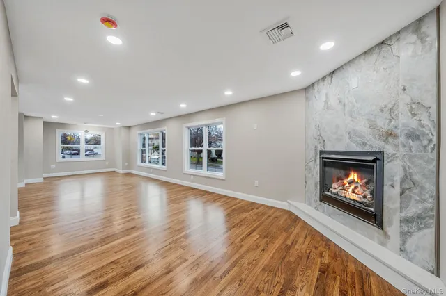 a view of an empty room with a window and fireplace