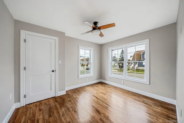 a kitchen with stainless steel appliances granite countertop a refrigerator a stove a sink dishwasher and white cabinets with wooden floor