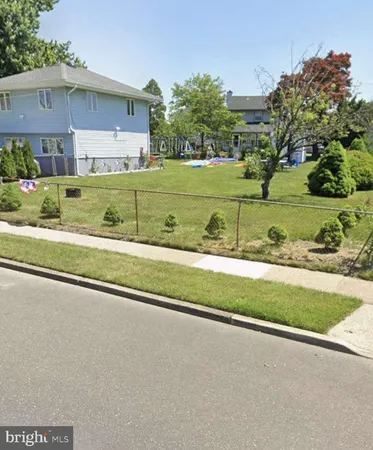a view of a house with a big yard and a large tree