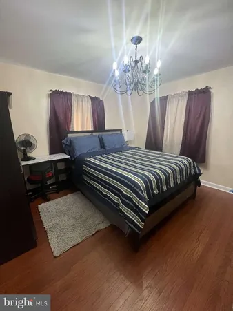 a bedroom with a bed dresser and window