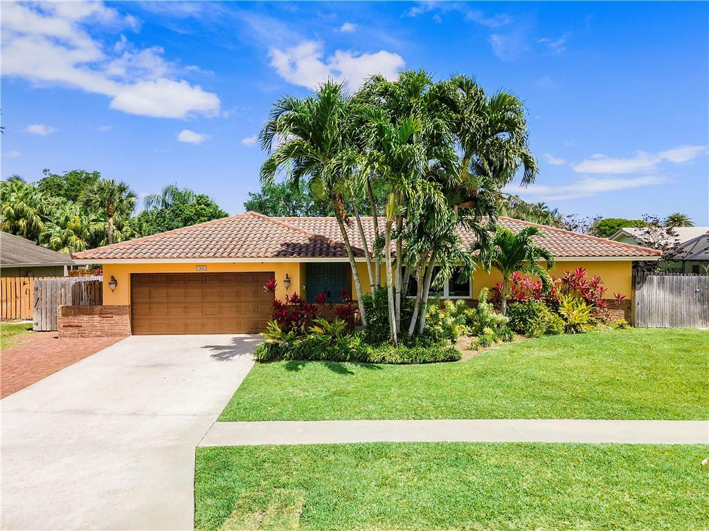 1423 Southwest 14th Street Boca Raton, FL 33486 - Photo 1 of 45 a front view of a house with a yard