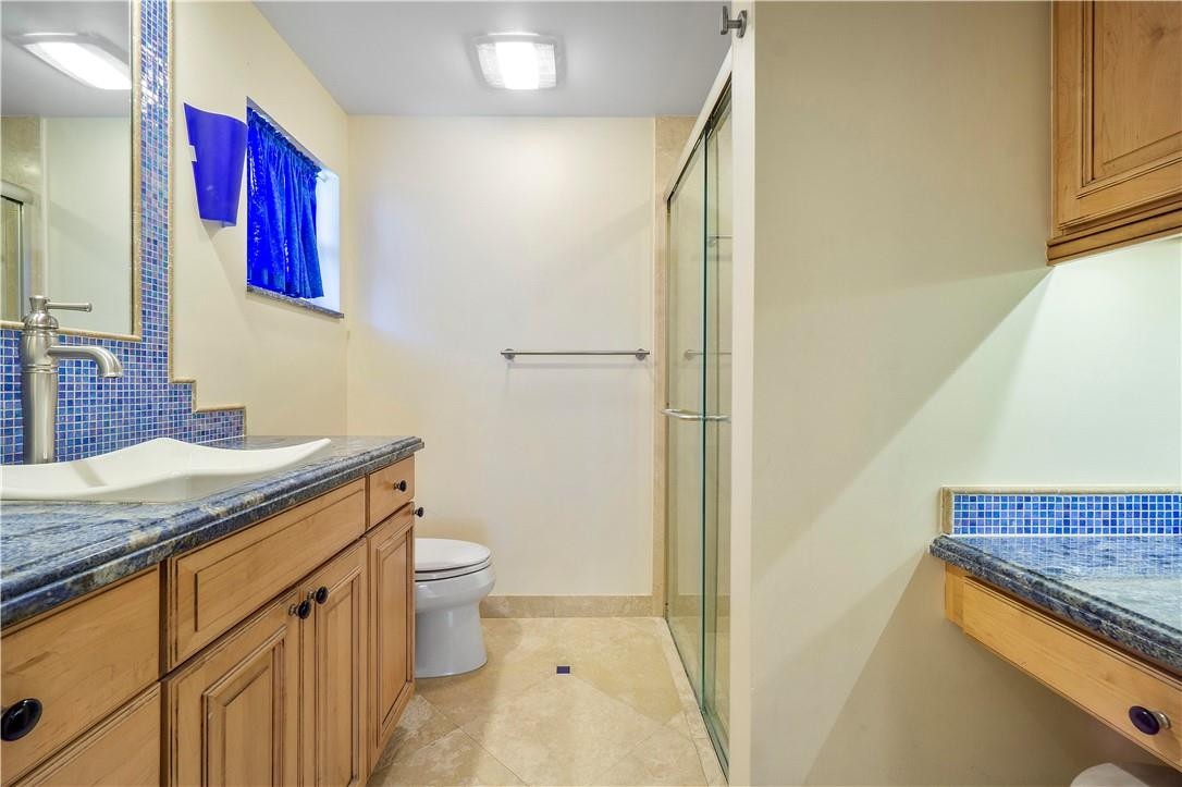 1423 Southwest 14th Street Boca Raton, FL 33486 - Photo 12 of 45 a bathroom with a granite countertop sink a toilet and a mirror