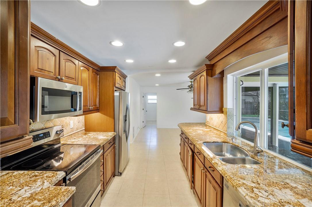 1423 Southwest 14th Street Boca Raton, FL 33486 - Photo 2 of 45 a kitchen with counter top oven stove sink and glass door