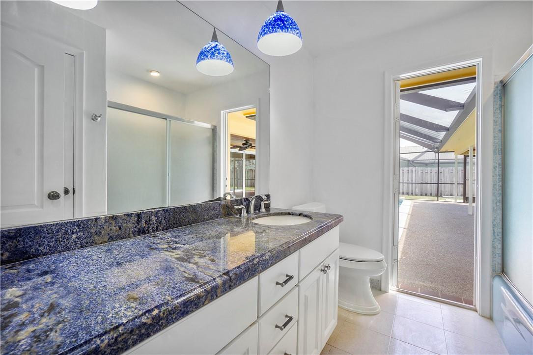 1423 Southwest 14th Street Boca Raton, FL 33486 - Photo 23 of 45 a bathroom with a granite countertop sink mirror vanity and toilet