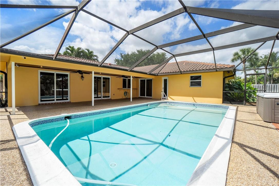 1423 Southwest 14th Street Boca Raton, FL 33486 - Photo 30 of 45 a backyard of a house with table and chairs under an umbrella