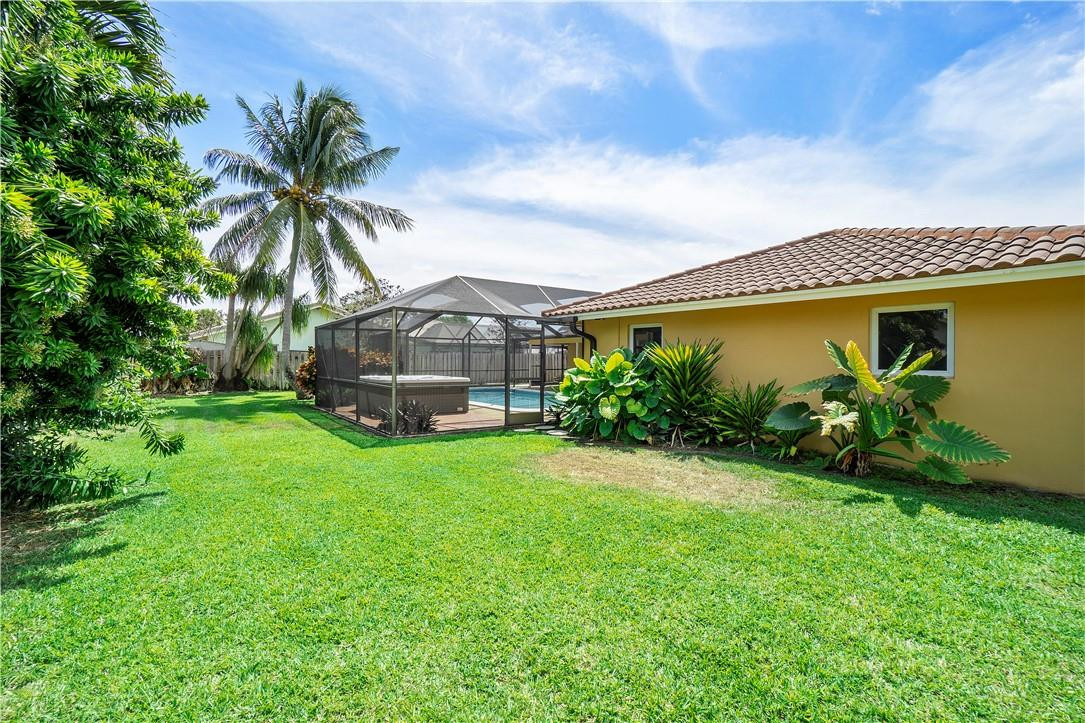 1423 Southwest 14th Street Boca Raton, FL 33486 - Photo 34 of 45 a palm tree sitting in front of a house with a garden