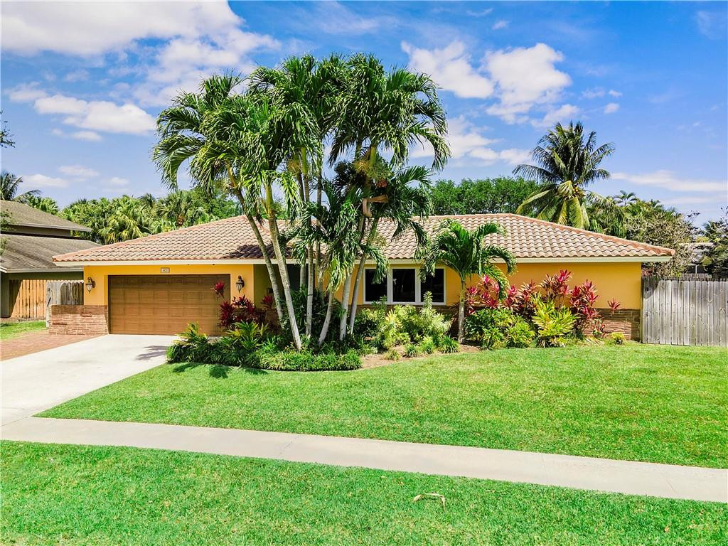 1423 Southwest 14th Street Boca Raton, FL 33486 - Photo 35 of 45 a front view of a house with a yard and potted plants