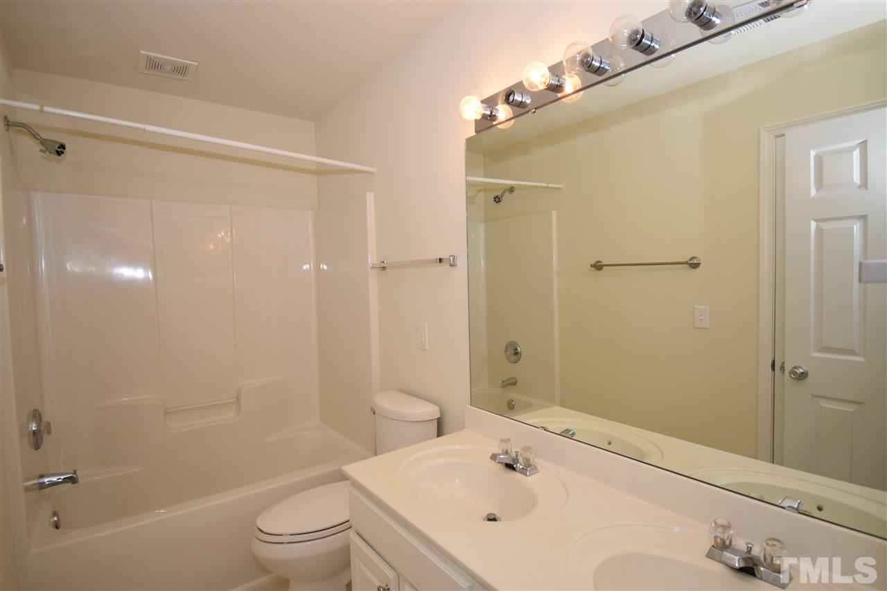 7413 Lagrange Drive Raleigh, NC 27613 - Photo 11 of 12 a bathroom with a bathtub shower sink vanity and toilet