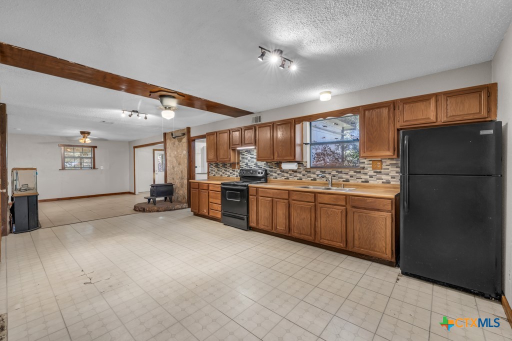 500 Line Camp Loop Spring Branch, TX 78070 - Photo 19 of 48 a kitchen with stainless steel appliances a refrigerator and wooden cabinets
