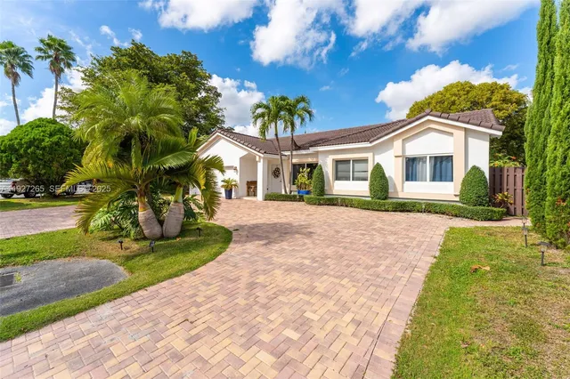 a front view of a house with a yard and potted plants