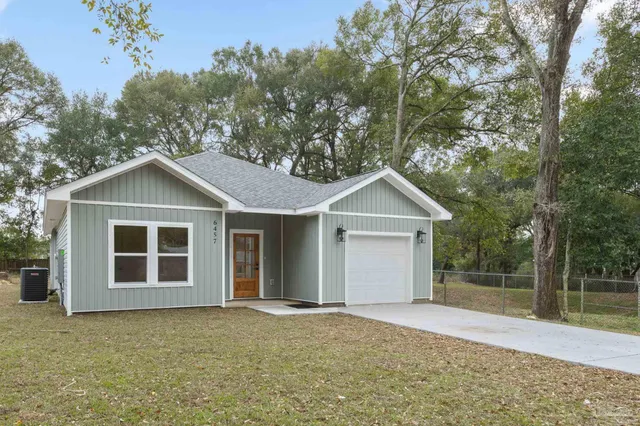 front view of a house with a yard and trees