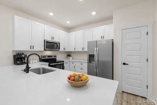a kitchen with stainless steel appliances a refrigerator sink and cabinets