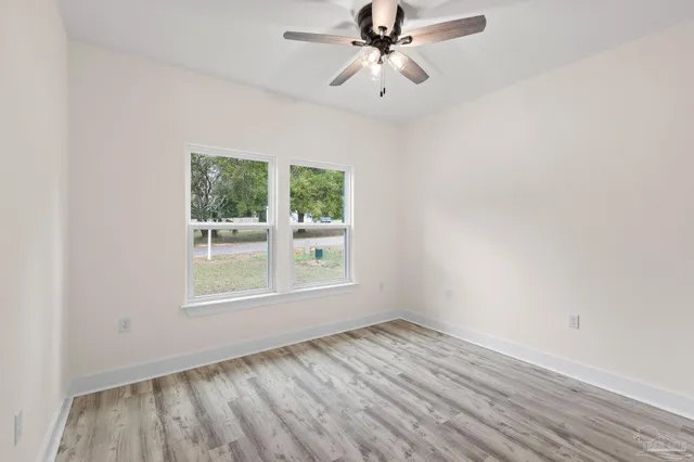 a view of a room with wooden floor and a ceiling fan