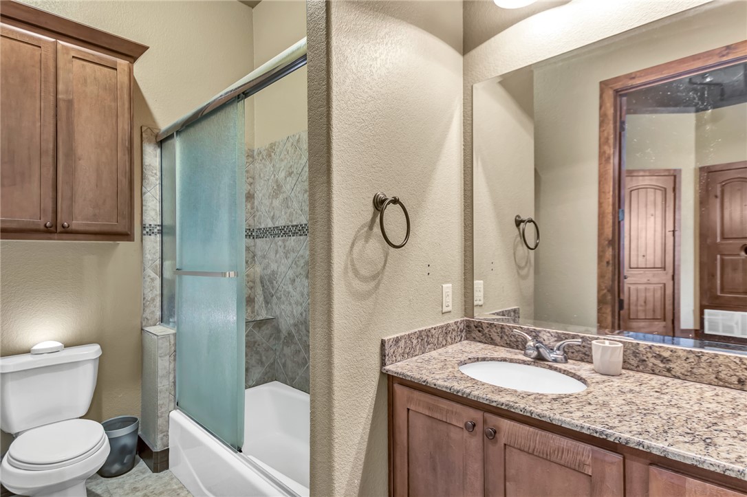 211 North Main Street, Unit 22 Bryan, TX 77803 - Photo 11 of 11 a bathroom with a granite countertop sink toilet and shower