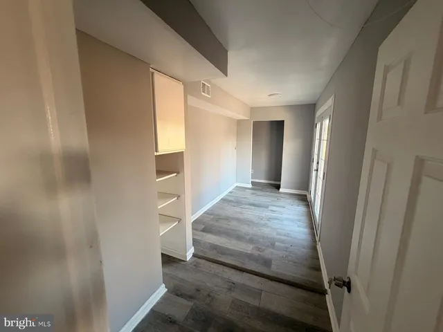 a view of empty room with wooden floor