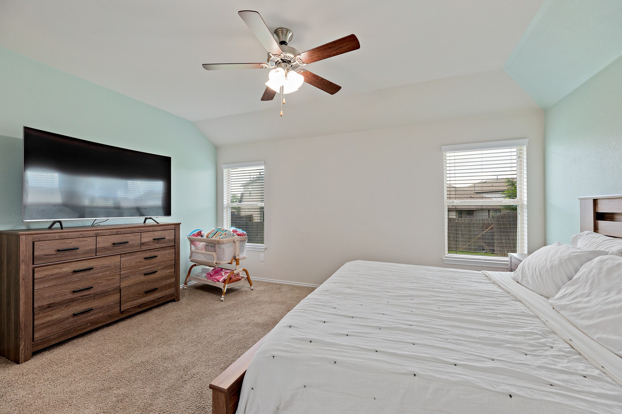 382 Limerick Road Buda, TX 78610 - Photo 15 of 20 Relax in comfort within this well-lit bedroom, featuring high ceilings and soft carpet underfoot.
