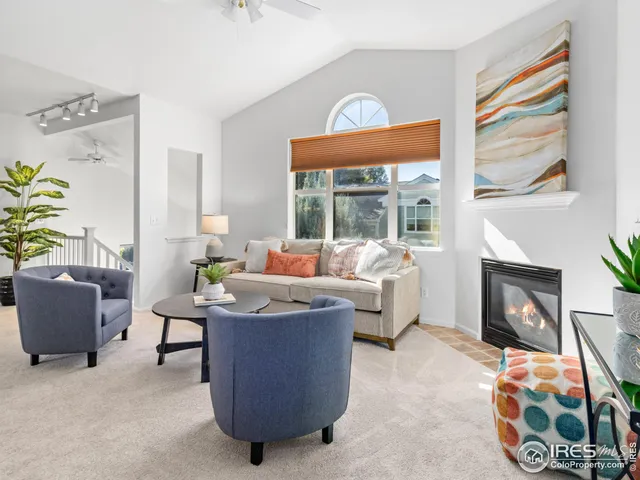 a living room with furniture a fireplace and a floor to ceiling window