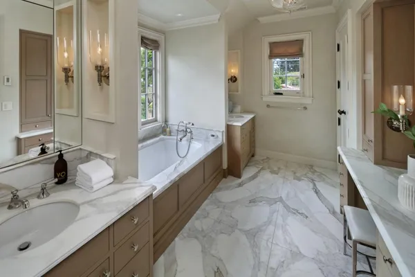 a bathroom with a tub sink and mirror