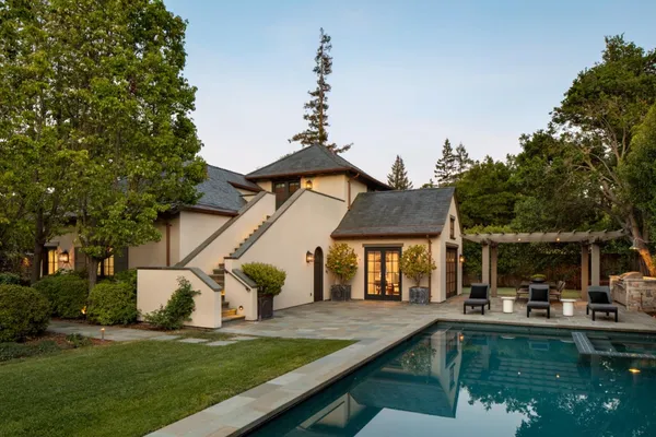 a view of house with swimming pool and a yard