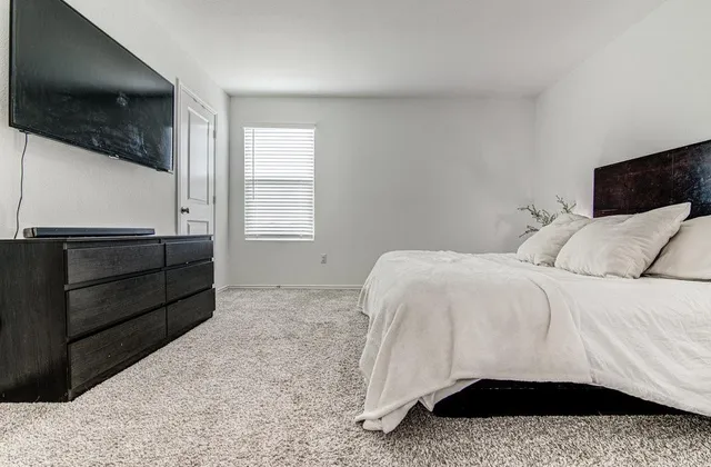 a bedroom with a bed and a television