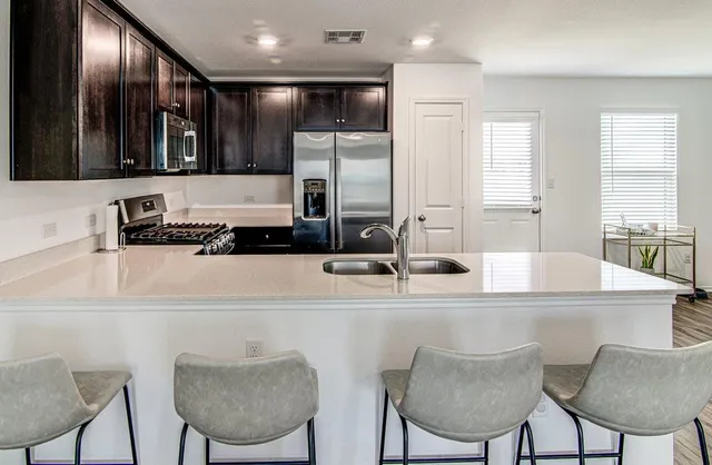 a kitchen with stainless steel appliances granite countertop a sink and a refrigerator
