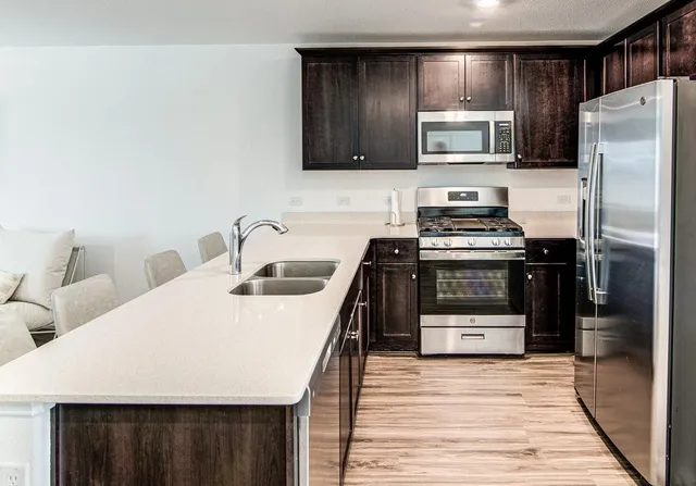 a kitchen with stainless steel appliances a stove a sink and a refrigerator