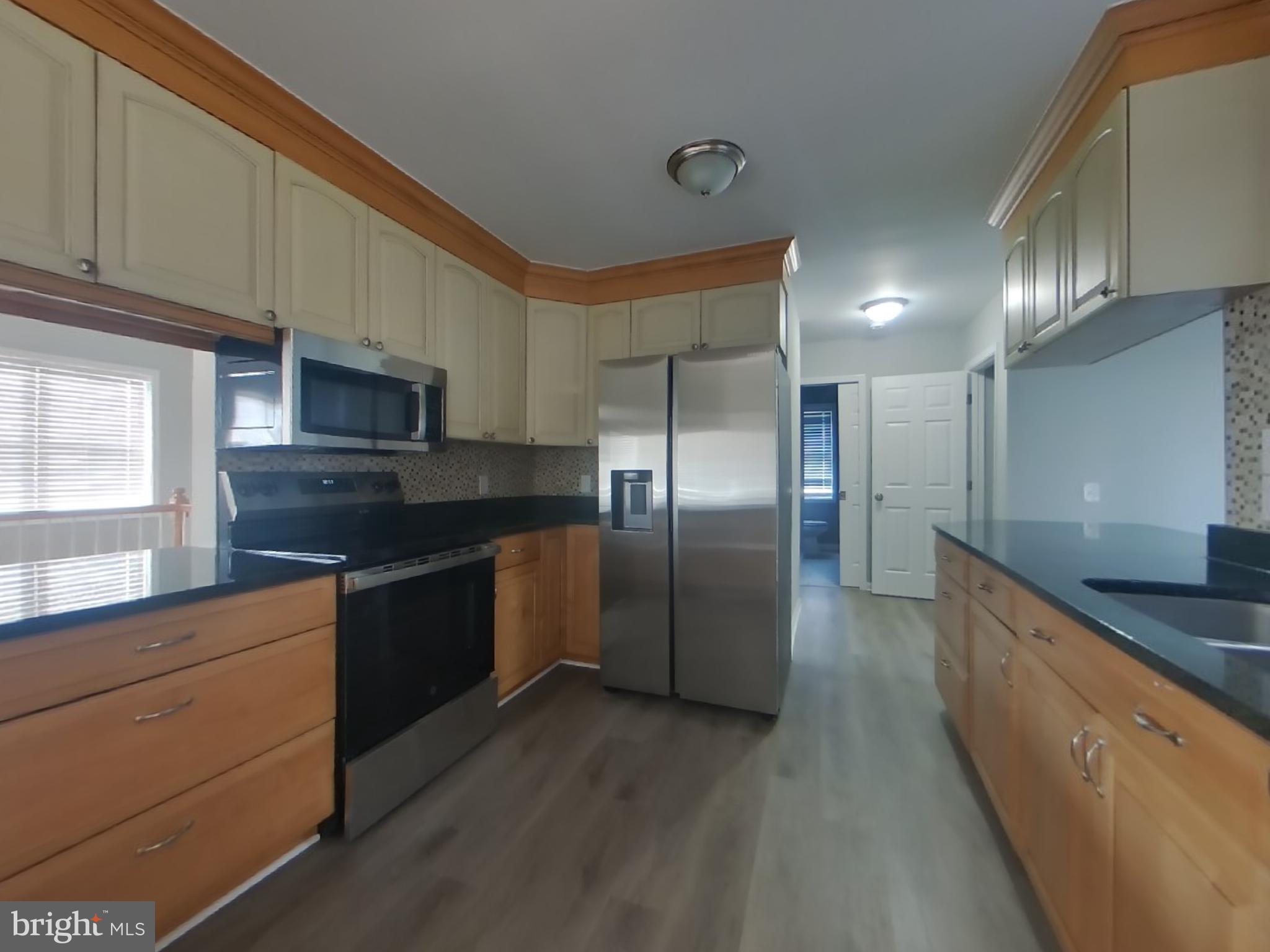 1614 Thomas Road Fort Washington, MD 20744 - Photo 4 of 20 a large kitchen with granite countertop a large counter top stainless steel appliances and cabinets