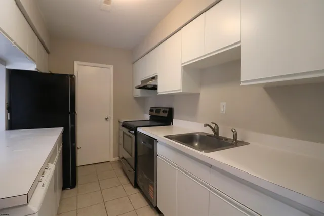 a kitchen with a sink and a refrigerator